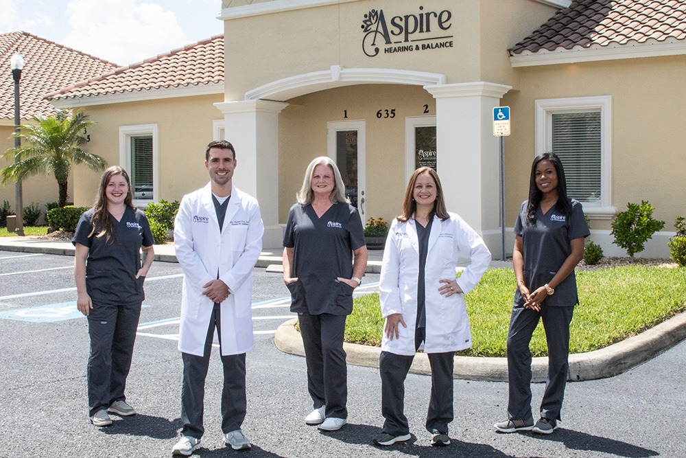 Aspire Hearing team standing in front of office building