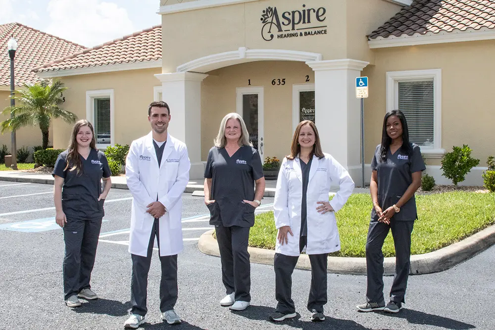 Aspire Hearing team standing in front of office building