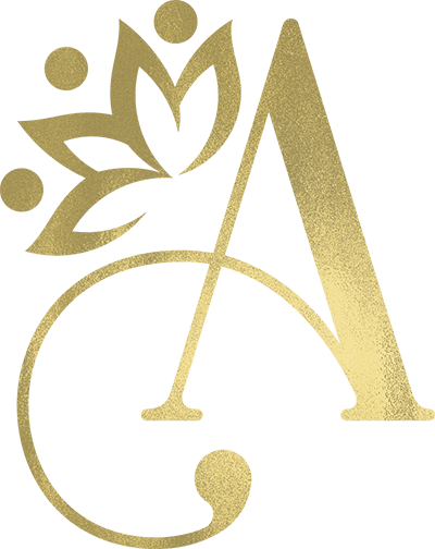 A gold letter A with a stylized crown or floral design above the left side, incorporating three dots and petal shapes, on a light background.