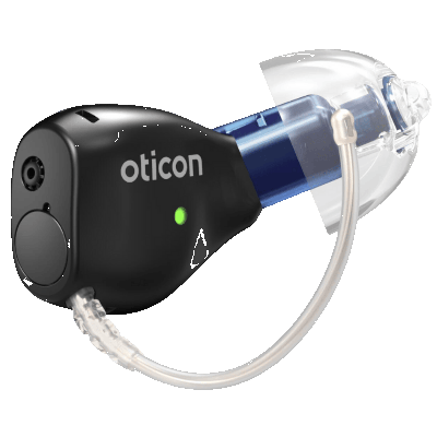 A close-up of a black Oticon hearing aid with a clear earpiece, a green indicator light, and a thin, curved connecting tube.