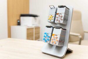 A desktop display stand holding four stacks of color-coded circular material samples.